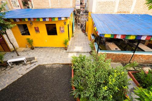 an overhead view of a yellow building with a blue roof at Kwabahal Boutique Hostel in Kathmandu