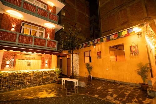 a building with a bench in a courtyard at night at Kwabahal Boutique Hostel in Kathmandu