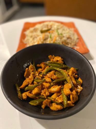 a black bowl of food with green beans and rice at Fogland Hotel Nathia Gali in Nathia Gali