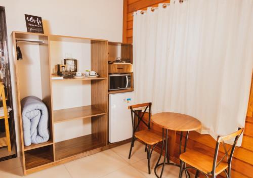 eine kleine Küche mit einem Tisch und einem Kühlschrank in der Unterkunft Pousada Gagno in Domingos Martins
