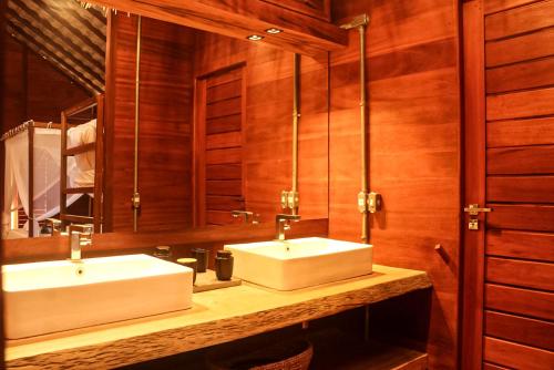 a bathroom with two white sinks and a mirror at Kabana Hotel in Prea
