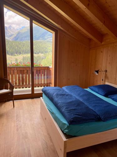 a bed in a room with a large window at BerglandHof Hotel Ernen in Ernen