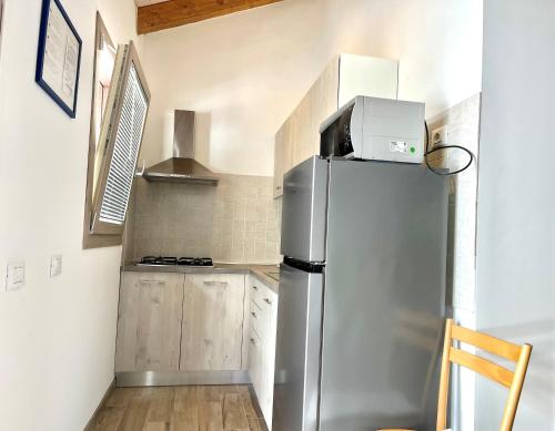 a kitchen with a stainless steel refrigerator with a box on top at Villaggio Camping Valdeiva in Deiva Marina