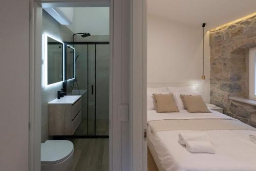 um quarto com 2 camas, um lavatório e um espelho em Lapidea apartments em Skradin