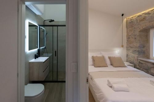 a bedroom with two beds and a sink and a mirror at Lapidea apartments in Skradin