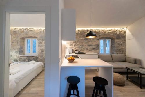uma cozinha e sala de estar com uma parede de pedra em Lapidea apartments em Skradin
