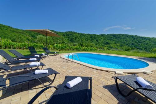 a group of chairs and a swimming pool at Holiday Home Brajdice in Cerovlje