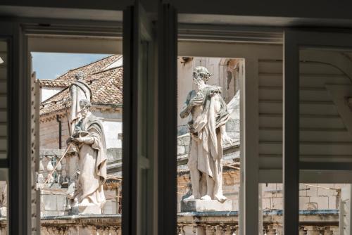 uma estátua de duas pessoas ao lado de um edifício em The Bassegli - Gozze Palace em Dubrovnik