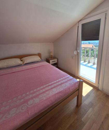 a bedroom with a bed and a large window at Bella Vista Apartment in Podgorica