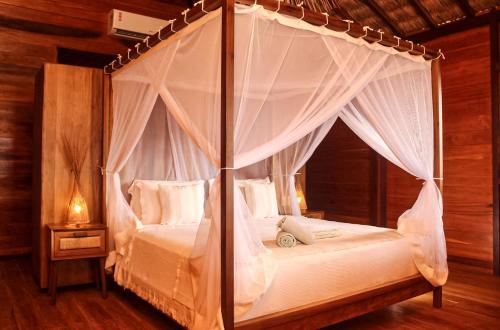a bedroom with a canopy bed with white sheets and pillows at Kabana Hotel in Prea