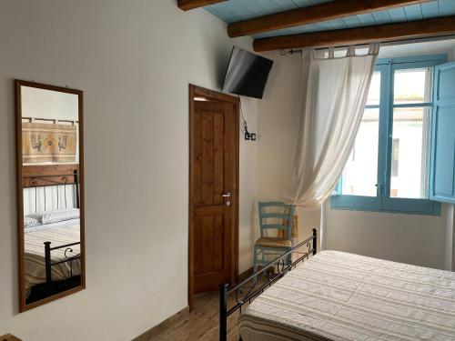 a bedroom with a mirror and a bed and a window at B&B Alba Chiara in Oristano