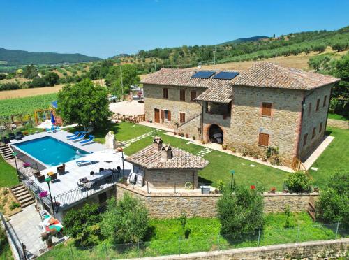 een extern uitzicht op een groot stenen huis met een zwembad bij Villa aquila in Agello