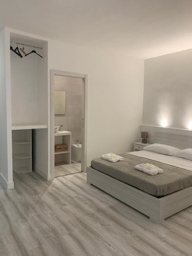 a white bedroom with a bed and a mirror at CagliariParadiseApartment it Marina in Cagliari