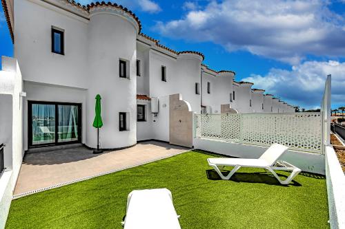 聖米格爾德阿沃納的住宿－Ocean Boulevard Tenerife，坐在带草的院子顶上的白色椅子
