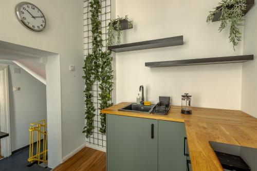 a kitchen with a counter and a clock on the wall at First Hostel in Bucharest