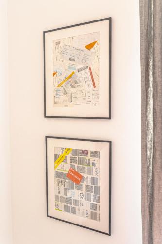 two framed prints of architectural drawings on a white wall at First Hostel in Bucharest