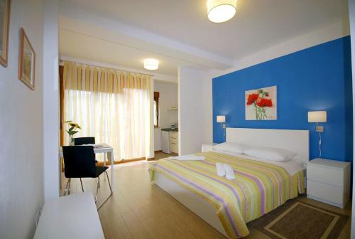 una camera con letto e parete blu di Apartments Sponza a Rovigno (Rovinj)