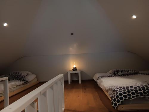 two beds in a room with a candle on a table at Loft la plus belle vue du lac Léman Montreux in Montreux
