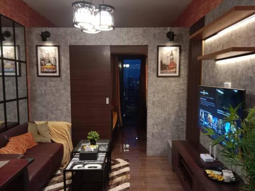 ein Wohnzimmer mit einem Sofa und einem Flachbild-TV in der Unterkunft Modern Condo with Stunning Views at a Prime Location - Air Residence in Manila