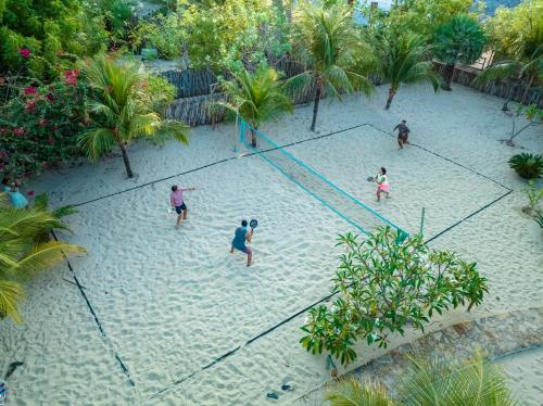 a group of people playing in a volley ball net at La Cozinha Bungalow in Barra Grande
