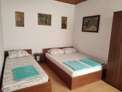 duas camas num pequeno quarto com lençóis azuis em Apartment Mejdan em Mostar