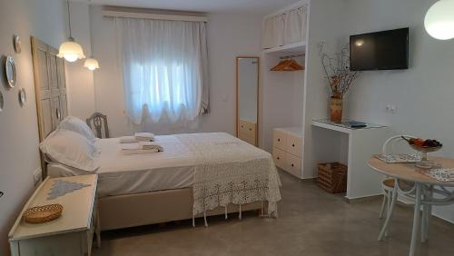 a small bedroom with a bed and a table at Est 1852 - Cozy in Andros