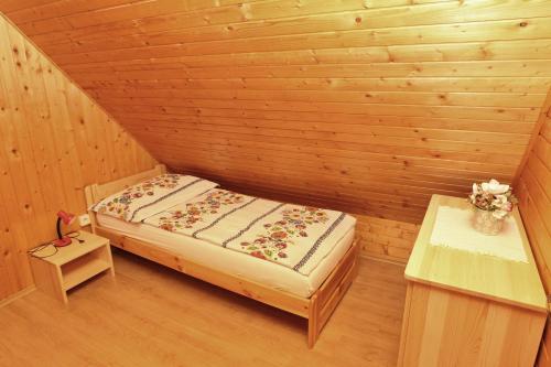 a small room with a bed in a wooden cabin at Chata Soňa in Terchová