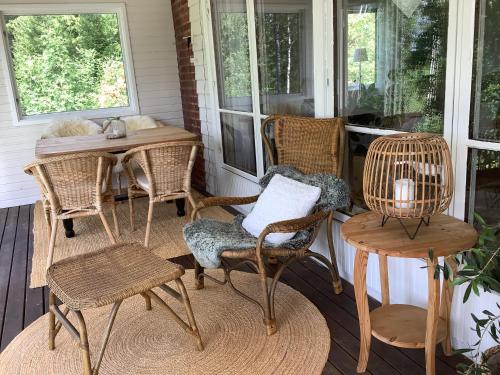 a porch with wicker chairs and a table at Sjösikten in Ätran