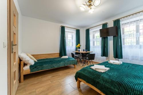 Habitación de hotel con 2 camas y mesa en Dom Krawca - pod Chojnikiem, en Jelenia Góra