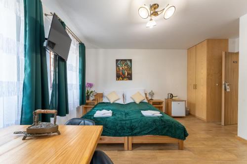 a bedroom with a bed with a green bedspread at Dom Krawca - pod Chojnikiem in Jelenia Góra
