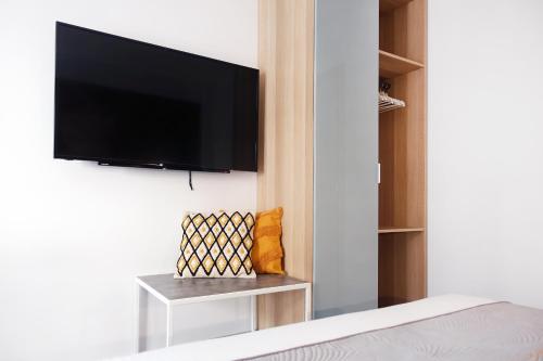 a bedroom with a flat screen tv hanging on a wall at Okean Apartments in Ierissos