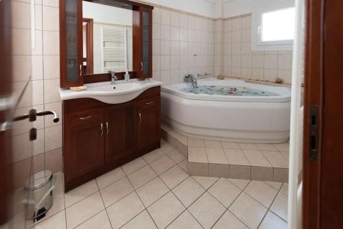 a bathroom with a tub and a sink at Villa Demy in Patra