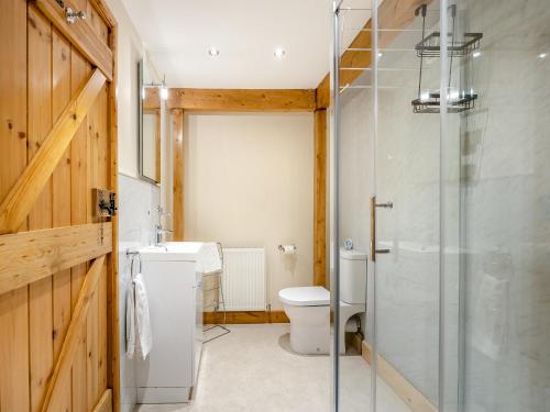 a bathroom with a toilet and a glass shower at The Granary - Uk44520 in North Thoresby