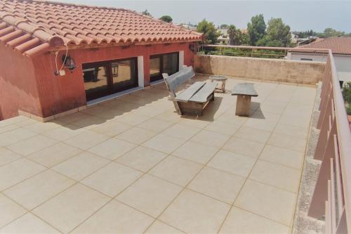 a patio with a bench and a table on a roof at Villa Demy in Patra