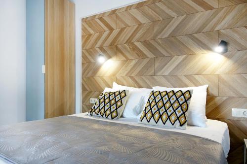 a bedroom with a bed with a wooden headboard and two pillows at Okean Apartments in Ierissos