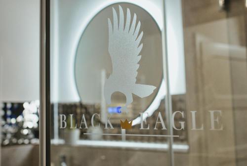 a white bird sign on a glass window with a black triangle at Residence Black Eagle Lubmin Strand in Lubmin