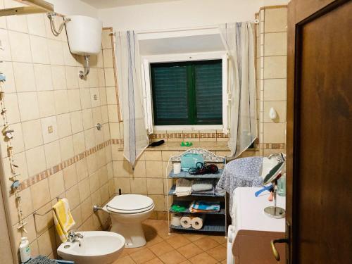 bagno con servizi igienici, lavandino e finestra di Casa Blu a Pisa