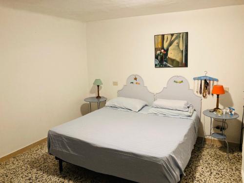una camera con un letto e due tavoli con lampade di Casa Blu a Pisa