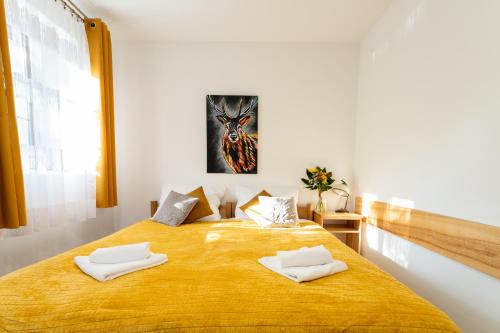 a bedroom with a bed with two white towels on it at Dom Krawca - pod Chojnikiem in Jelenia Góra