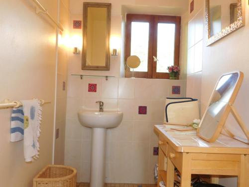 a bathroom with a sink and a toilet and a mirror at Gite de France Lacam in Bannes