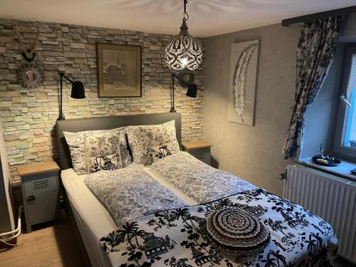 - une chambre avec un lit et un mur en briques dans l'établissement B&B De Eifelhoeve, à Herresbach