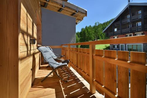a chair sitting on the deck of a house at Alpen Resort Bivio in Livigno