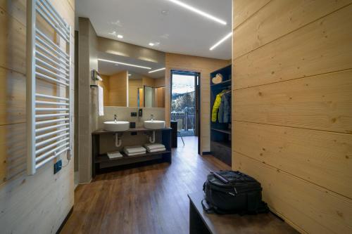 a bathroom with two sinks and wooden walls at Alpen Resort Bivio in Livigno