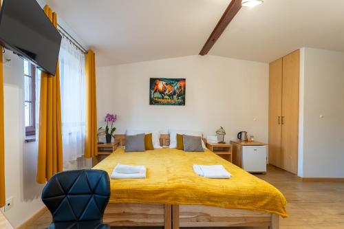 a bedroom with a large bed with a yellow blanket at Dom Krawca - pod Chojnikiem in Jelenia Góra