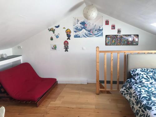 une chambre avec un lit et une chaise rouge dans l'établissement MAISON SPACIEUSE LA ROCHELLE, à La Rochelle