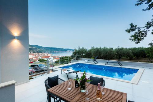 a patio with a table and a swimming pool at Seaside Elegance Suites in Komiža