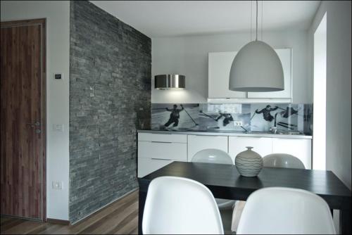 a kitchen with a black table and white chairs at House Neza in Kranjska Gora