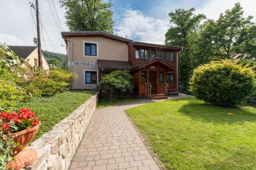 a house with a stone wall and a walkway at Dom Krawca - pod Chojnikiem in Jelenia Góra