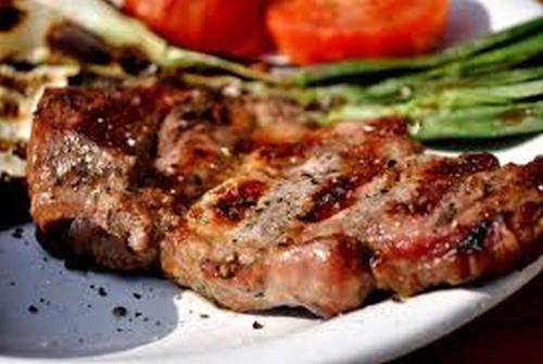 a piece of steak on a white plate with asparagus at Hotel Bucegi Portile Regatului in Paraul Rece