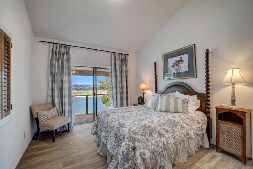 a bedroom with a bed and a large window at Perched Above the River in Lago Vista